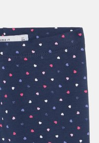 Leggings navy con piccoli motivi a cuore multicolore in rosa, bianco e viola. Tessuto morbido con una vestibilità aderente e cintura elastica.