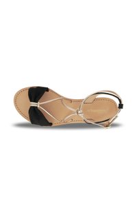 Sandali in suede neri con dettaglio a fiocco, finiture metalliche e soletta in pelle beige. Cinturino alla caviglia regolabile per una vestibilità perfetta.