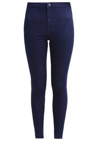 Džíny s vysokým pasem, úzké v tmavém denimovém provedení. Hladká textura, žádné viditelné opotřebení, s předním zapínáním na knoflík a úzkými nohavicemi.