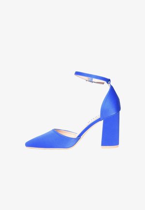 Scarpa di raso blu con tacco alto, punta appuntita e cinturino alla caviglia, tacco a blocco e suola beige su sfondo bianco.