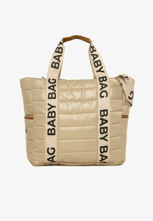 Beżowa torba dla niemowląt z wypełnieniem, z czarnym napisem "BABY BAG" na paskach, posiadająca strukturę wykończenia oraz brązowe akcenty po bokach.