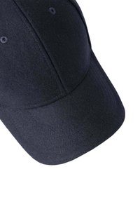 Gorra de lana negra con visera curva, que presenta un acabado texturizado y seis orificios de ventilación, destacando un diseño limpio y minimalista.
