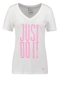 Camiseta blanca de algodón con escote en V, que presenta un gran texto rosa "JUST DO IT". Muestra el logo de Nike en rosa en la parte inferior derecha.