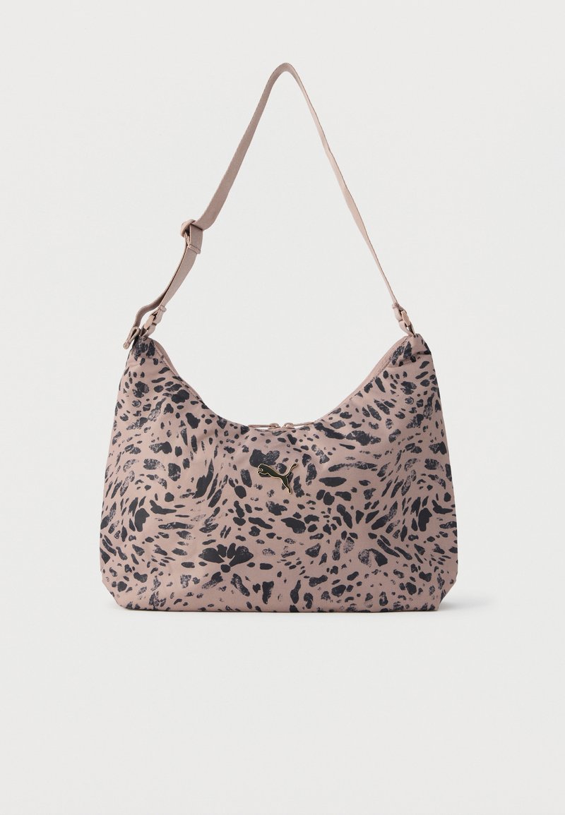 Ροζ ανοιχτή τσάντα ώμου με μοτίβο από μαύρες αφηρημένες κηλίδες και ρυθμιζόμενο ιμάντα, με μικρό χρυσό λογότυπο Puma στο κέντρο μπροστά.
