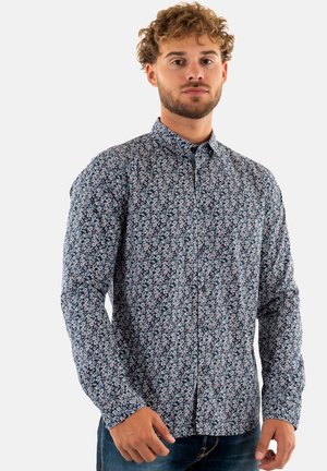 Chemise à manches longues à boutons avec un fond bleu marine et un motif floral blanc, rose et vert. Le tissu est doux avec un design de col classique.