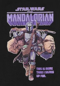 Camiseta gráfica con una figura armada que lleva bolsas y una criatura. El texto púrpura en la parte inferior dice: “ESTO ES MÁS DE LO QUE FIRMÉ.”