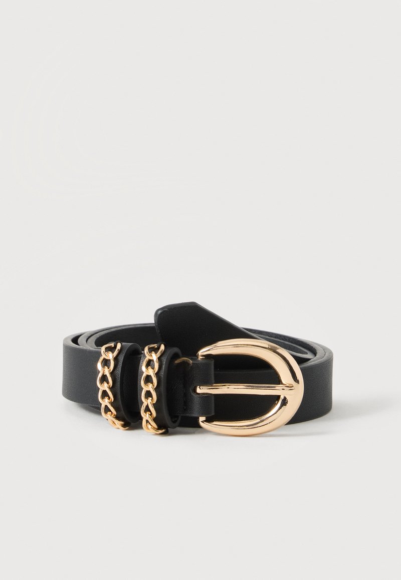 Ceinture en cuir noire avec boucle arrondie dorée et deux détails en boucle de chaîne dorée, enroulée sur une surface blanche.