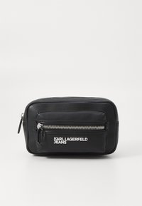 Schwarze Ledertasche mit silbernem Reißverschluss und vorderer Tasche. Mit dem Logo "KARL LAGERFELD JEANS" in Weiß. Rechteckige Form, glatte Textur.