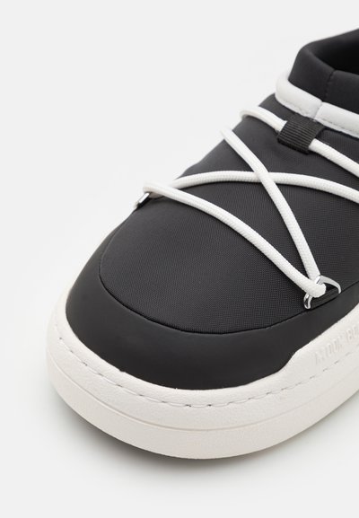 Musthave mustad tume tekstuuriga ülemise osaga, valgete nööridega ja paksu kreemja tallaga. Omab ümmargust varbasahtlit ja minimalistlikku disaini.