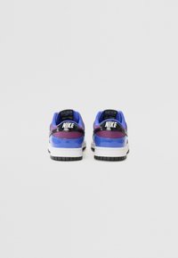 Nike-sneakers i lila och blå med en glansig yta, med svarta detaljer och vita sulor, sedd från baksidan.