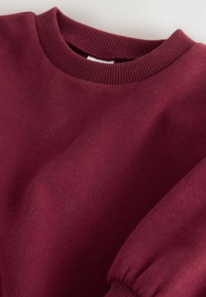 Bordeauxfarbenes Sweatshirt mit geripptem Kragen und Bündchen, aus einem weichen Stoff mit leicht strukturiertem Finish, das einen lässigen Schnitt aufweist.