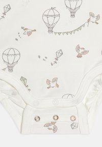 Biała bodziak w niemowlęcym rozmiarze, zdobiona wzorem z balonami na gorące powietrze, ptakami i latawcami w stonowanych kolorach, z trzema zapięciami na zatrzaski u dołu.