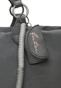 Sac fourre-tout gris en matériau texturé, avec une poignée enroulée, des accessoires en métal argenté et une étiquette de logo rose. Les accents comprennent des anneaux bouclés.