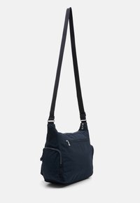 Navy blue shoulder bag with a textured fabric, featuring adjustable strap, zippered pockets, and a side pocket for additional storage.