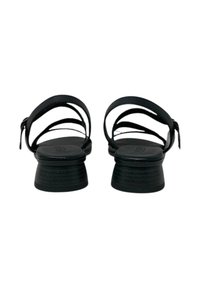 Sandali neri con multiple cinghie sottili e un piccolo tacco a blocco. Presentano una suola testurizzata e una cinghia posteriore sicura per un maggiore supporto.