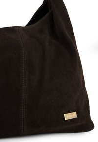 Black suede shoulder bag with a soft texture, featuring a gold-tone logo accent and visible stitching details along the seams.