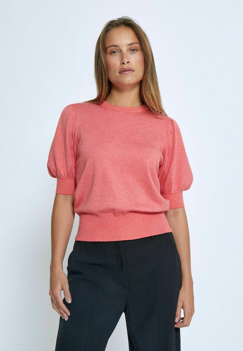 Maglione corto corallo a maniche corte con scollatura rotonda, polsini e orlo a coste. Realizzato in morbido tessuto a maglia con una vestibilità leggermente rilassata.