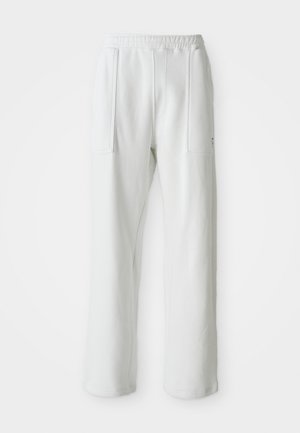 Witte casual broek met een elastische tailleband en grote voorzakken, weergegeven op een effen lichte achtergrond.