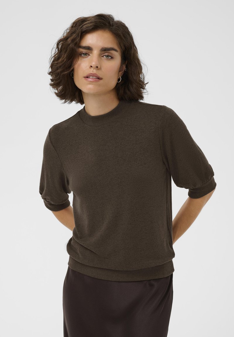 Brown knitted pullover with a round neckline and short, slightly puffed sleeves. The fabric appears soft and texture is smooth.