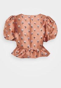 Satinöverdel i mjuk persika med puffärmar, blommönster i vitt och blått, rundad halsringning och volangkant. Dragkedja i ryggen för stängning.