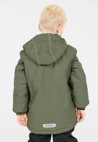 Giacca impermeabile verde con cappuccio, dotata di polsini elastici e diagonali riflettenti grigi. Logo del marchio visibile sul bordo posteriore.