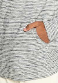 Grå och vit randig långärmad skjorta med en framficka, i en mjuk textur och en avslappnad passform.