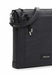 Svart läder crossbody-väska med en slät yta, dragkedjestängning, justerbart rem och en liten silverlogotypdetalj på framsidan.