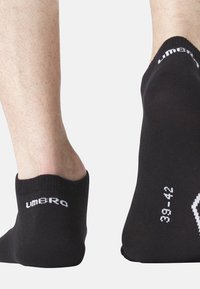 Chaussettes noires à la cheville en matériau lisse, avec un bord côtelé et un logo blanc. Taille imprimée sur les côtés.