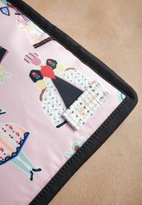 Bavlnená tkanina s ružovým pozadím, ktoré zobrazuje vzorované šaty, čierne lemovanie a vyšitý štítok s nápisom "Cath Kidston".
