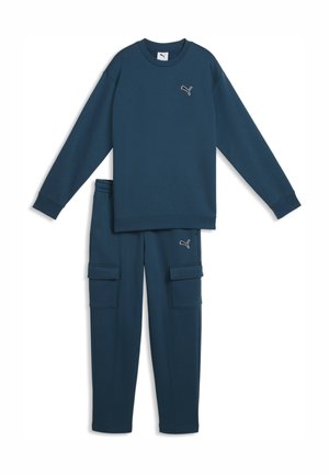 Ciemnoniebieska bluza z długim rękawem i pasujące bojówki z logo Puma na piersi i udzie, ułożone płasko na białym tle.