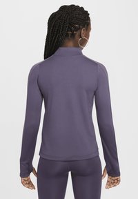 Top de manga larga morado con un alto cuello, hecho de una tela suave y elástica. Cuenta con mangas ajustadas y un dobladillo curvado en la parte de atrás.