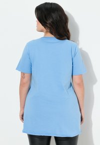 Camiseta de manga corta azul clara, hecha de una tela suave, con un escote redondeado y un corte relajado, con un dobladillo recto.