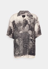 Camicia a maniche corte con bottoni, stampa dettagliata in bianco e nero di foreste e fogliame, colletto aperto e piccolo testo vicino all'orlo.
