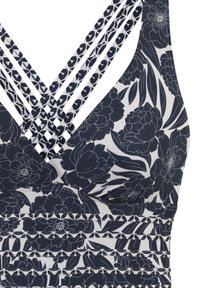 Jūrų mėlynos spalvos gėlių maudymosi kostiumėlio viršus su V formos iškirpte, turintis sluoksniuotą dirželį nugarinėje dalyje ir tekstūruotą horizontalų juostą, pagamintas iš tamprios medžiagos.