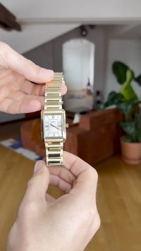 Kuldset tooni ristkülikukujuline käekell valge näo, rooma numbrite ja link-krae disainiga. Omab kuupäeva näidikut kella 6-as positsioonis.