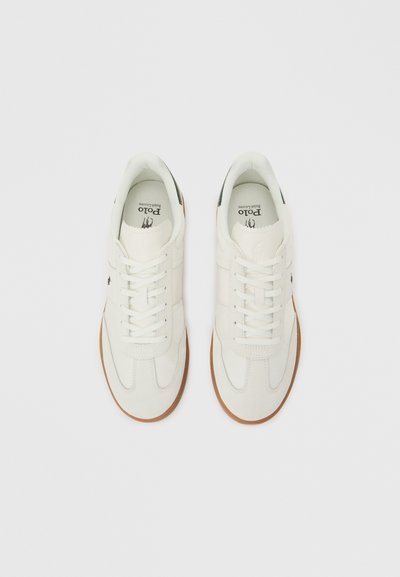 Ζευγάρι λευκά αθλητικά παπούτσια Polo Ralph Lauren με καφέ σόλες, φωτογραφημένα από πάνω σε ανοιχτό φόντο.