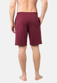 Shorts bordeaux à petits pois blancs, en tissu léger, avec une taille élastique et des poches latérales.