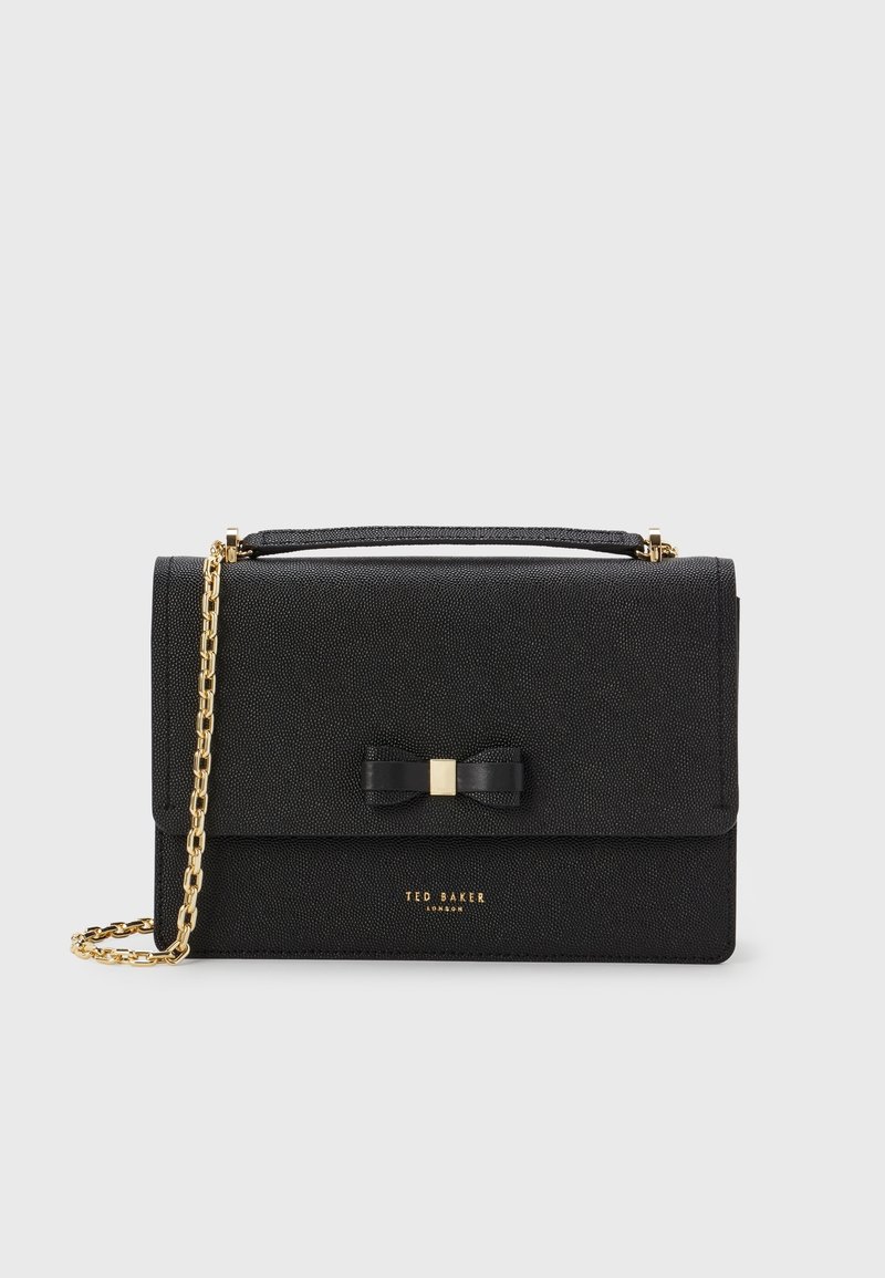 Borsa nera con texture, dotata di una tracolla in catena dorata, con un dettaglio a fiocco e il logo sulla parte anteriore. Chiusura magnetica nella parte superiore.