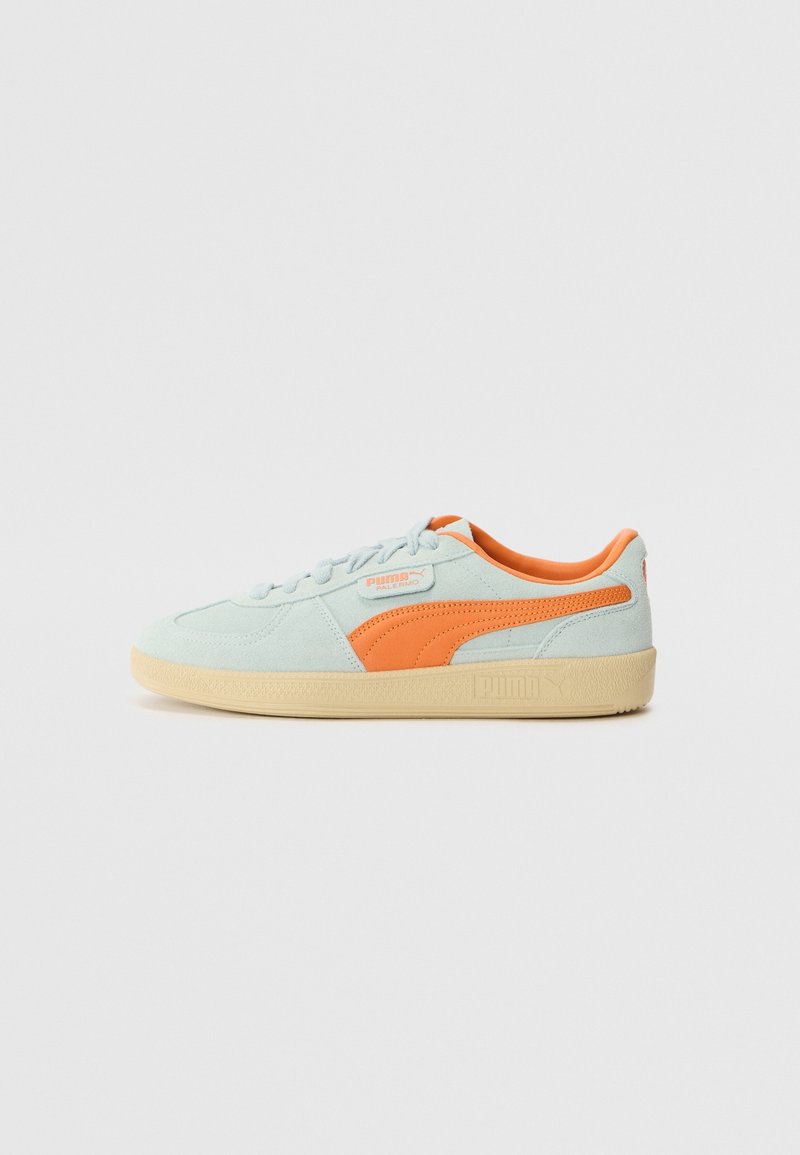 Baskets Puma en daim bleu clair avec bande orange et doublure, semelle beige et étiquette Puma Palermo sur le côté, présentées de profil.