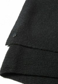 Melna vilnas šalle ar ribotu tekstūru. Tajā ir neliela melna pogu malas malā, kas uzsver tās tīro dizainu un mīksto materiālu.