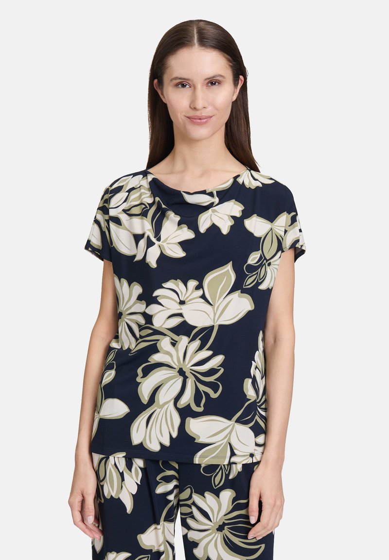 Marineblaue Blumenshirt aus leichtem Stoff, mit kurzen Ärmeln und einem runden Ausschnitt, verziert mit cremefarbenen und hellgrünen Blumenmustern.