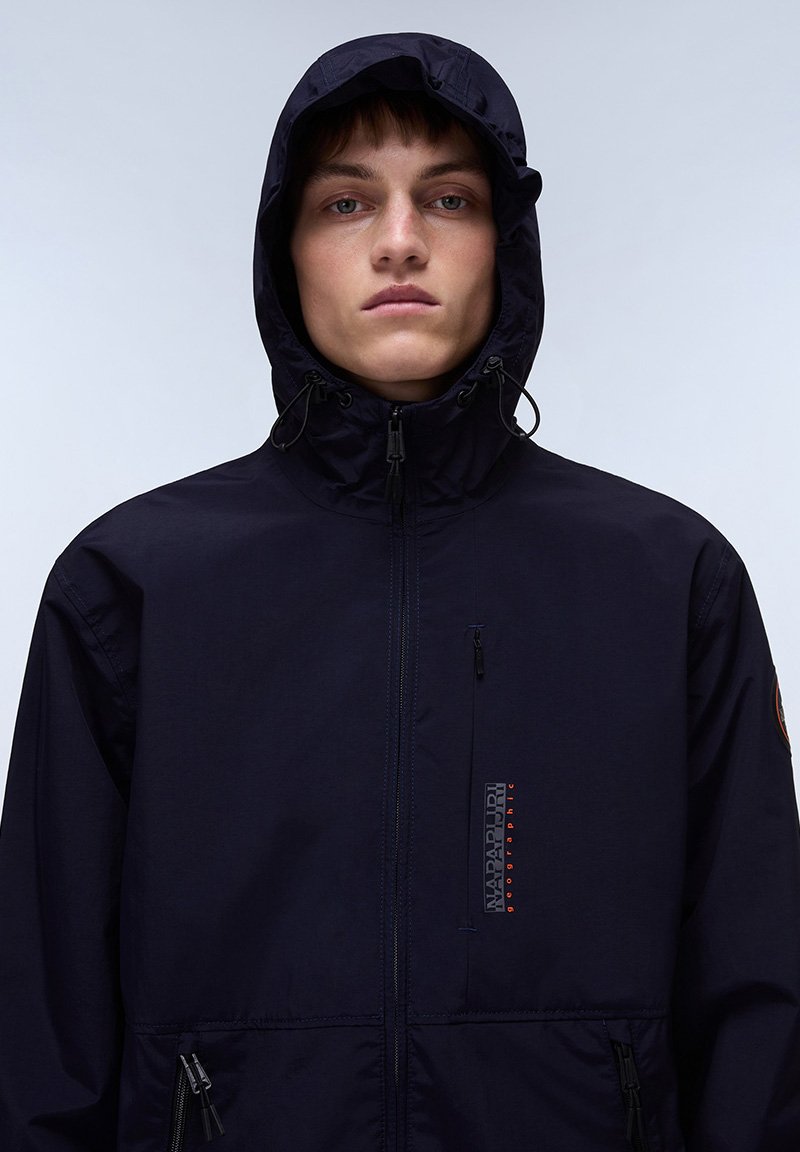Marineblaue Kapuzenjacke aus leichtem Material, mit einem Frontreißverschluss, verstellbarer Kapuze und Logodetail auf der Brust.