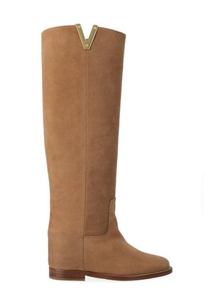 Stivale alto in pelle color abbronzatura con suola piatta in legno e dettaglio dorato a forma di V sul bordo superiore.