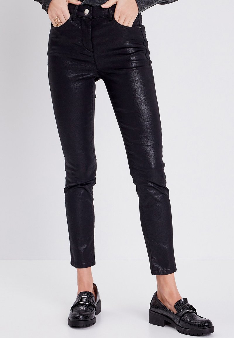 Zwarte, hoogwaardig skinny broek met een glanzende afwerking, voorzien van zijzakken en een knoopsluiting. Getextureerde stof met een strakke pasvorm.