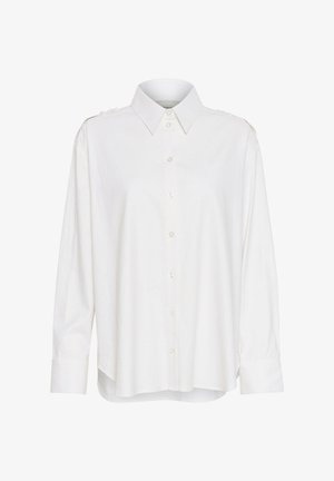 Balta marškinėliai su apykakle, ilgomis rankovėmis, šiek tiek laisva siluetu ir pečių akcentais. Pagaminti iš lengvos, tekstūruotos medžiagos.