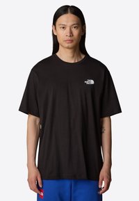 Sort bomulds t-shirt med rund hals og korte ærmer, prydet med et lille hvidt logo på venstre brystområde. Casual pasform.
