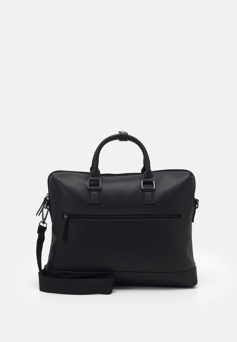 Mallette en cuir noir avec double poignée, poche avant zippée et bandoulière réglable sur un fond clair uni.