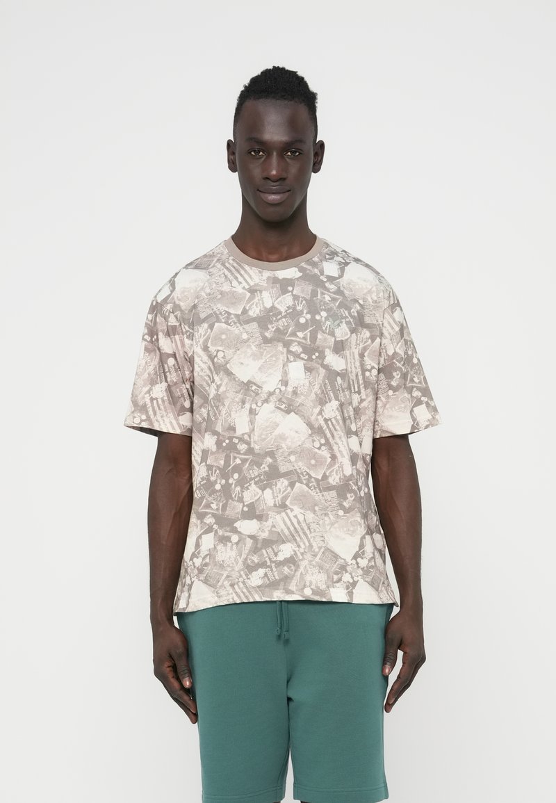 Πουκάμισο με κοντά μανίκια από ελαφρύ ύφασμα, με αφηρημένο γκρι και μπεζ μοτίβο, στρογγυλή λαιμόκοψη και άνετη εφαρμογή.