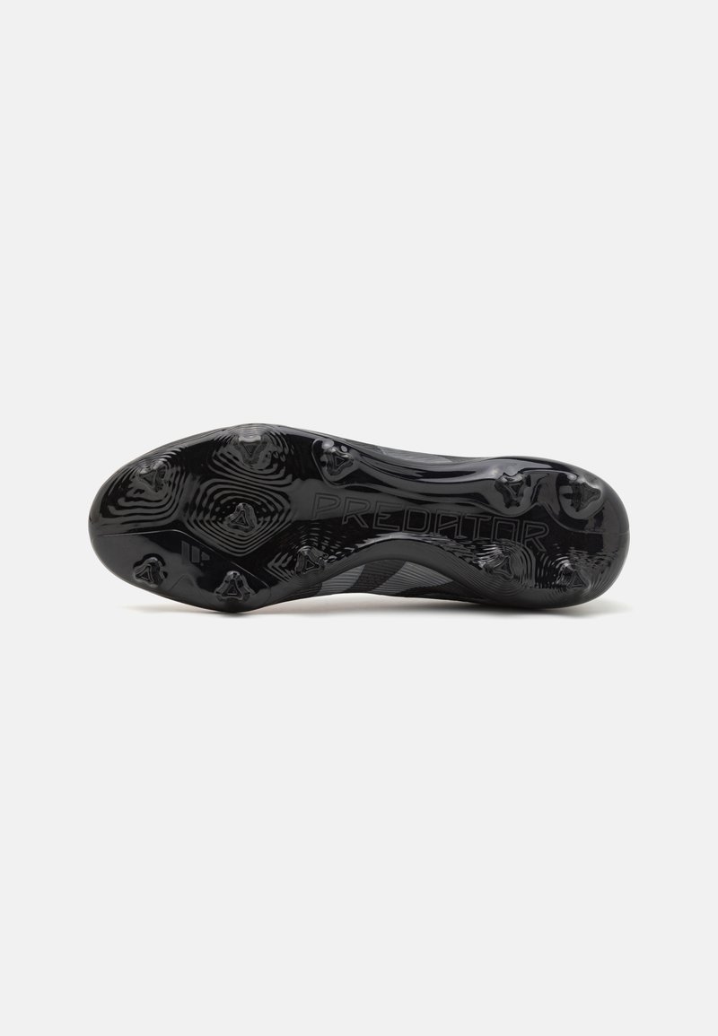 Suela de botas de fútbol Predator, de goma negra con un distintivo patrón texturizado, con tacos para tracción y marca grabada.