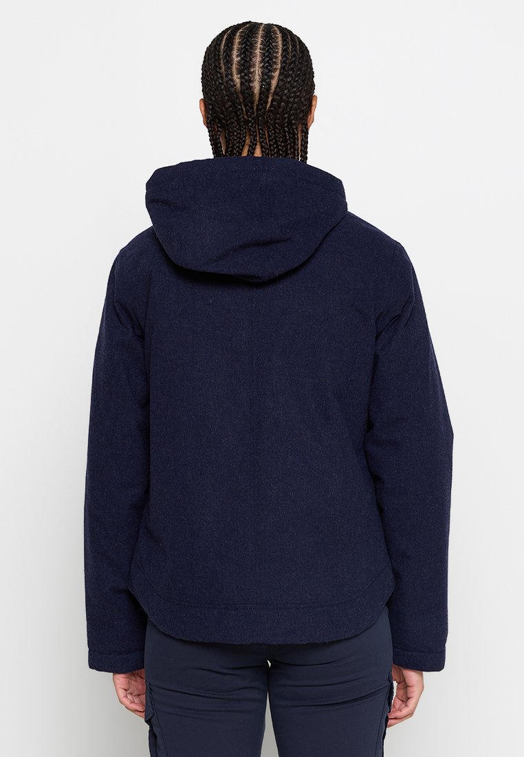 Giacca con cappuccio blu navy realizzata in tessuto morbido, caratterizzata da una vestibilità comoda, dettagli delle cuciture e polsini elasticizzati per una chiusura aderente.